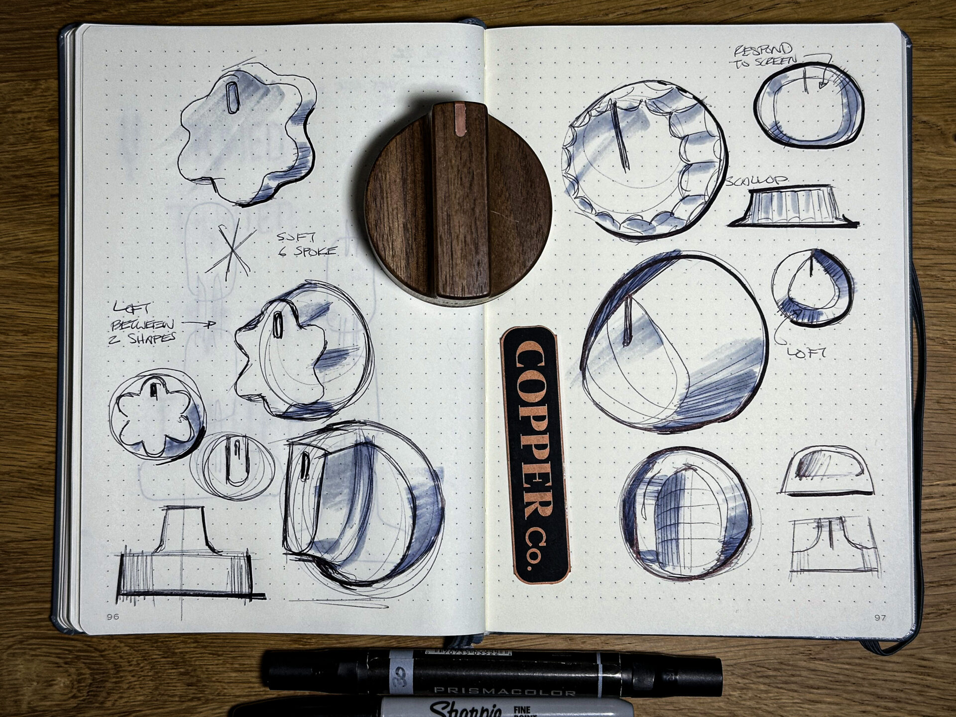 Sketchbook of range knob concepts, with a finished walnut knob