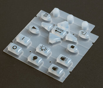 Silicone rubber keypads are a single molded rubber sheet with a grid of squishy bubbles that gives calculators and TV remotes their feel. When the user presses down on each molded dome, a carbon pill bridges two traces right on a PCB. They're very cheap to make in large volumes, which is why remotes use them.